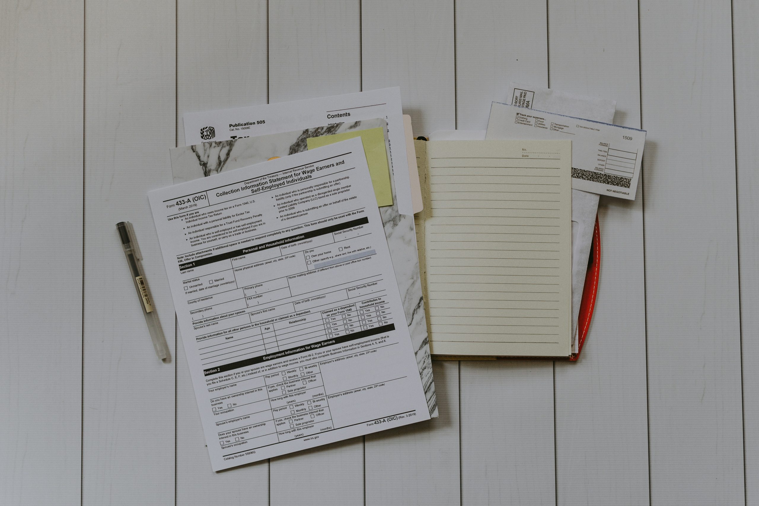 A pile of tax documents with folders and papers scattered.