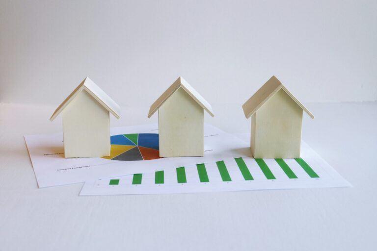 Paper models of houses with financial charts.