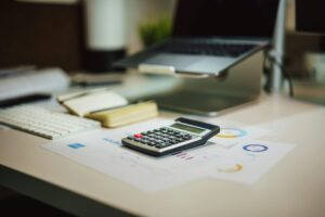 A financial desk setup with a calculator, documents, and digital elements.